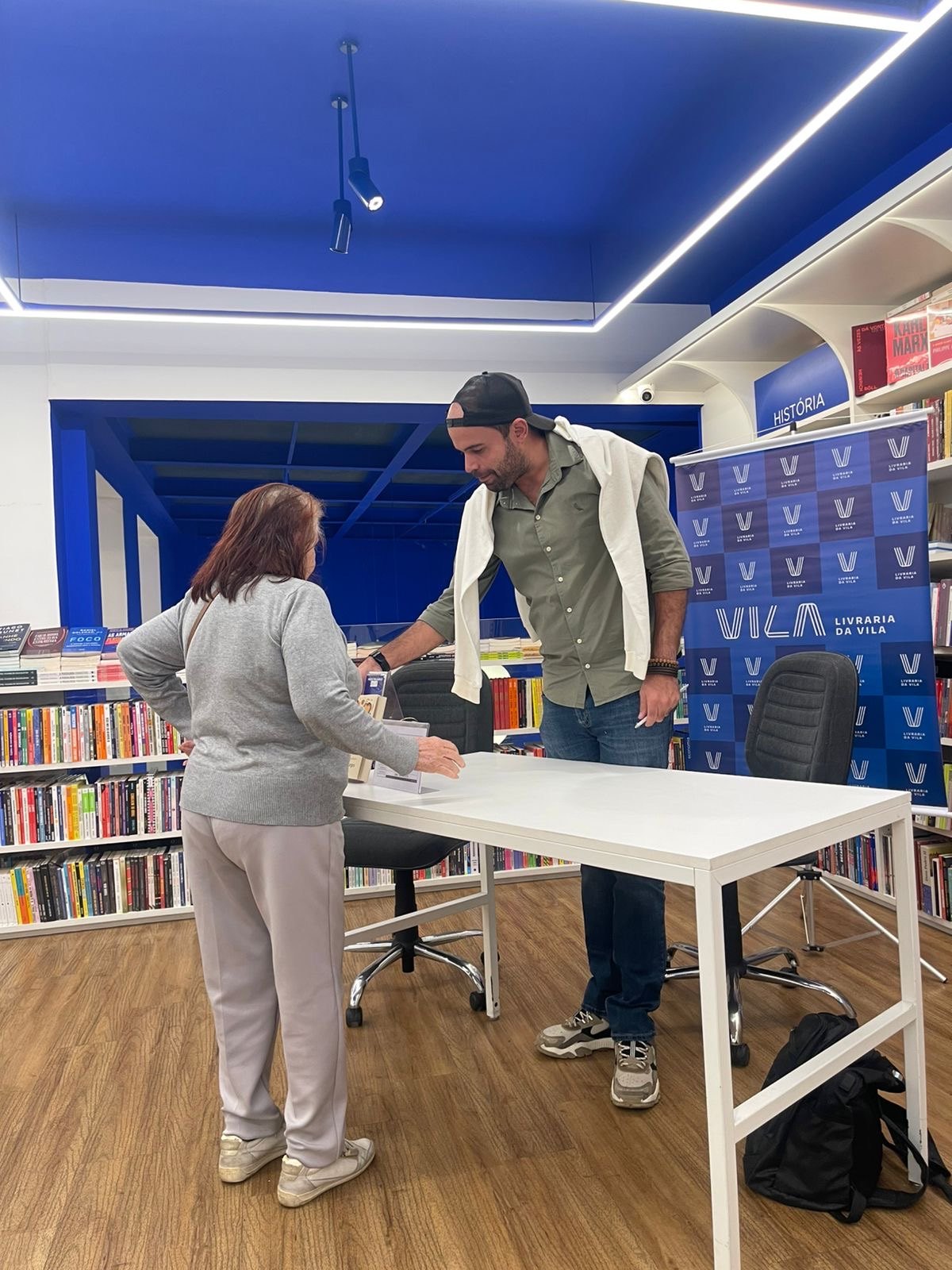 Ozanan Borges conversando com leitora em livraria
